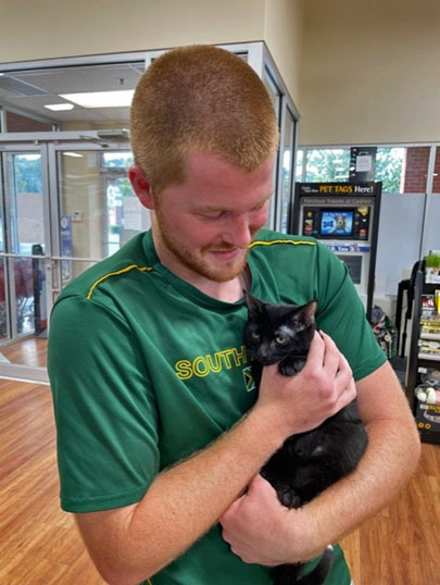 Harley, the black cat with his new guy.